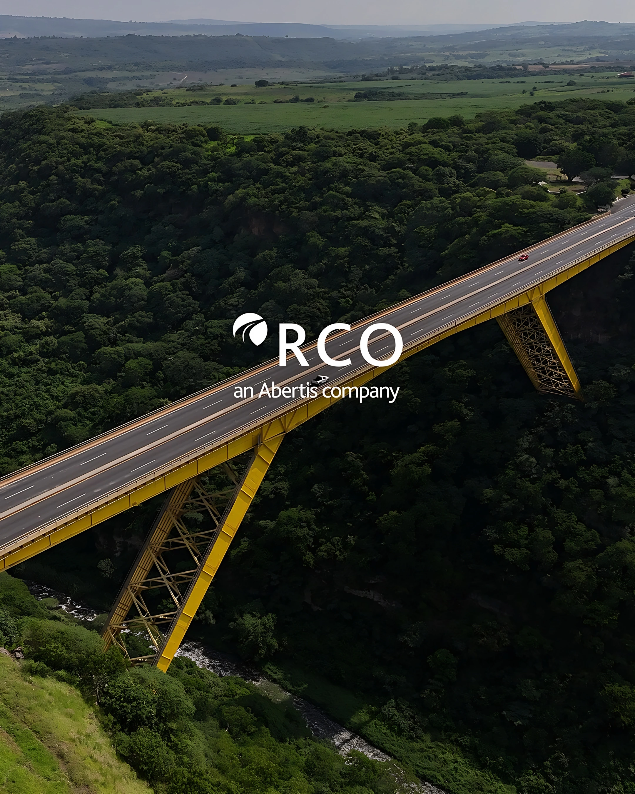 Aerial view of a highway bridge over a green valley with the RCO logo