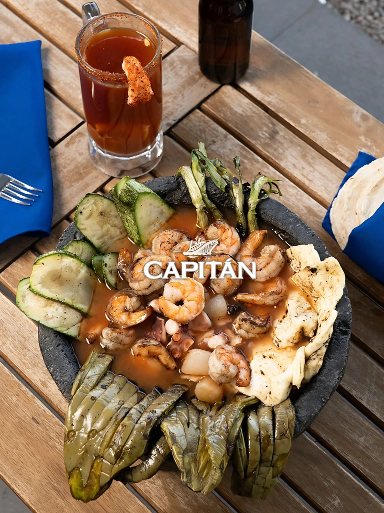Platillo de mariscos de Capitán Capico con una bebida